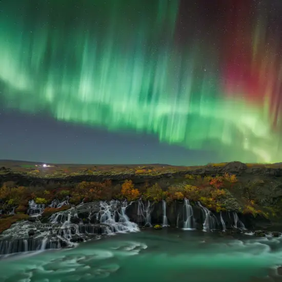 Northern Lights over Hraunfossar waterfall during a tour with Private Iceland
