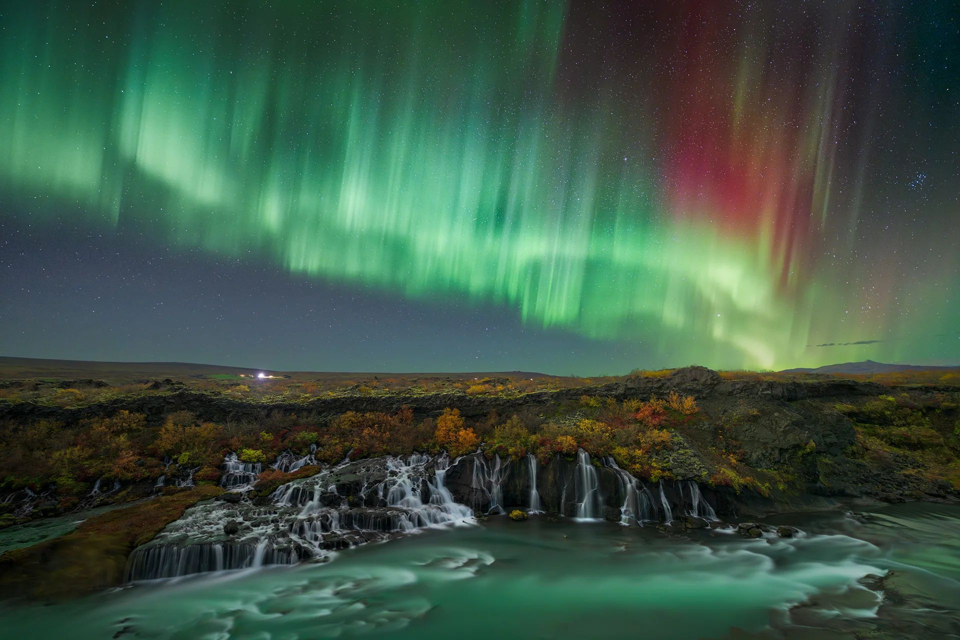 Northern Lights over Hraunfossar waterfall during a tour with Private Iceland